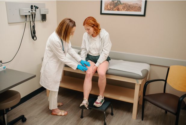 AFC physician checks woman’s leg for a rash.