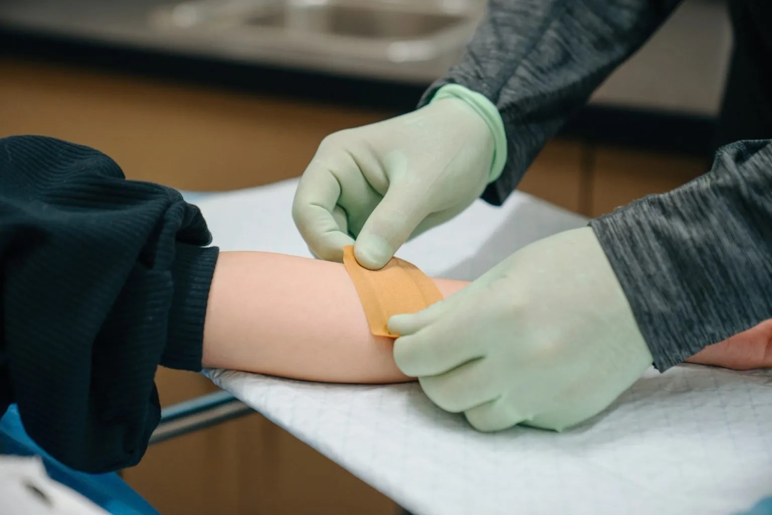 Provider bandaging patient's arm after cyst treatmentProvider bandaging patient's arm after cyst treatment