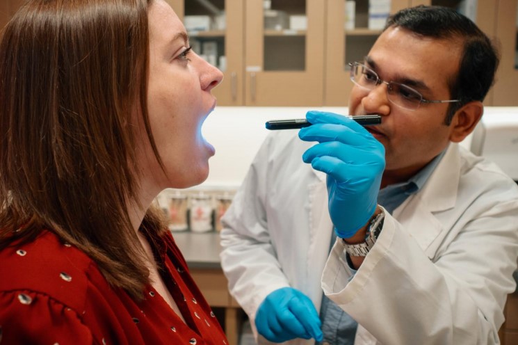 AFC provider checks patient’s throat with a light