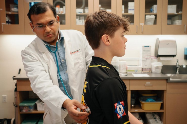 AFC provider listens to patient’s breathing with stethoscope