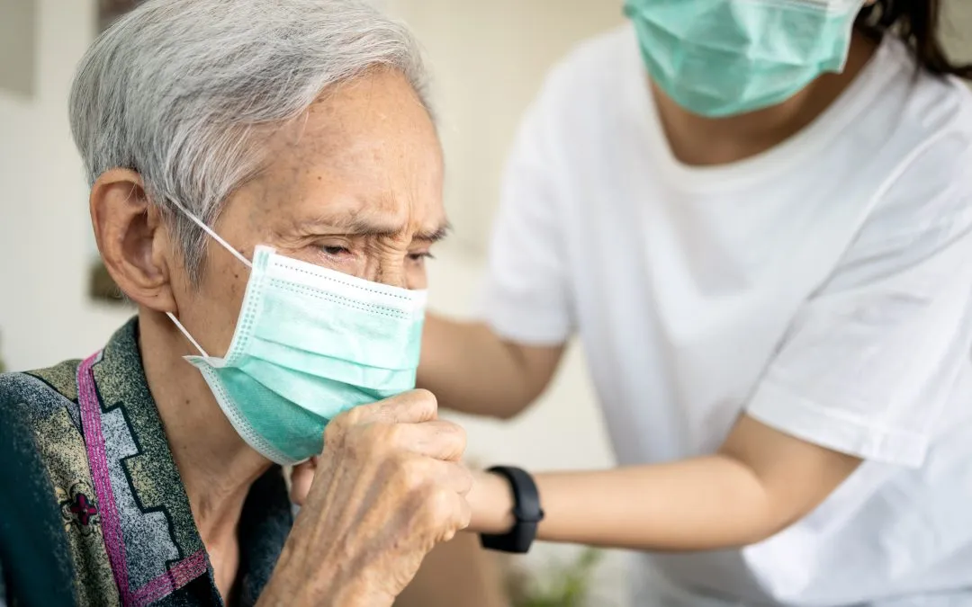 Old woman coughs into her mask