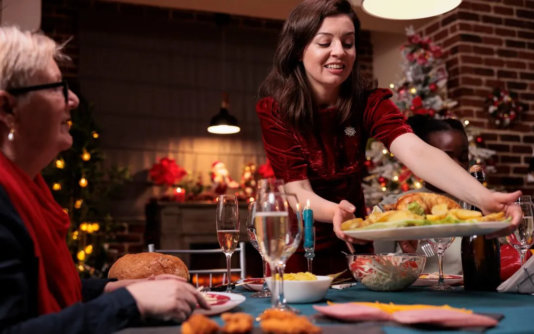 Woman sets prepared turkey down on the holiday dinner table