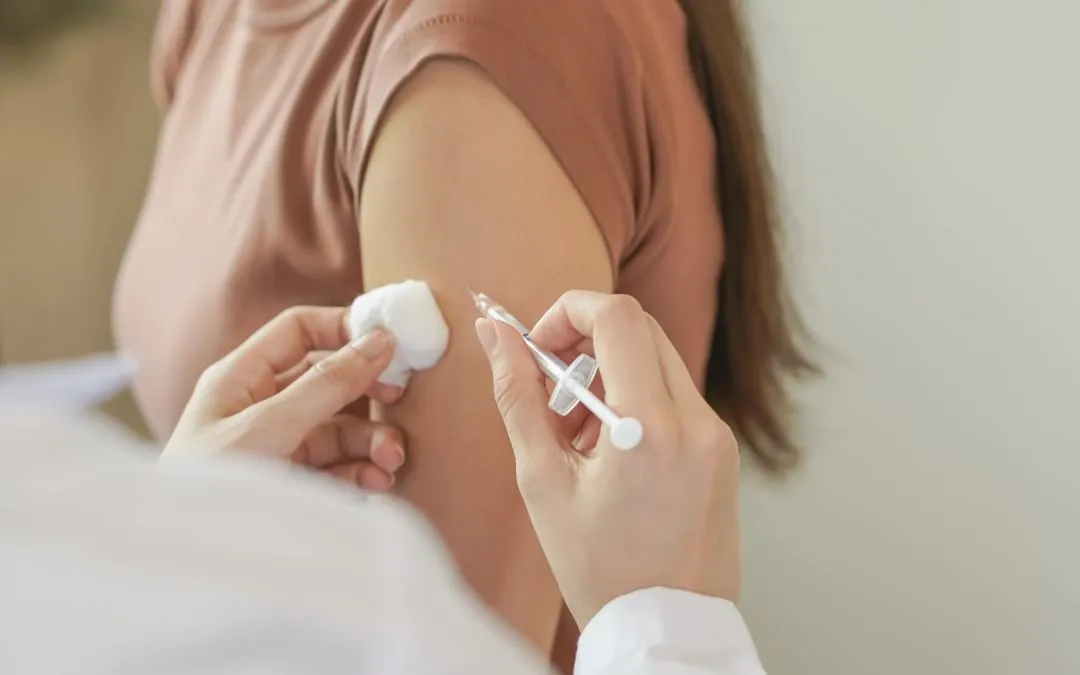 Hand of young woman provider giving syringe vaccine