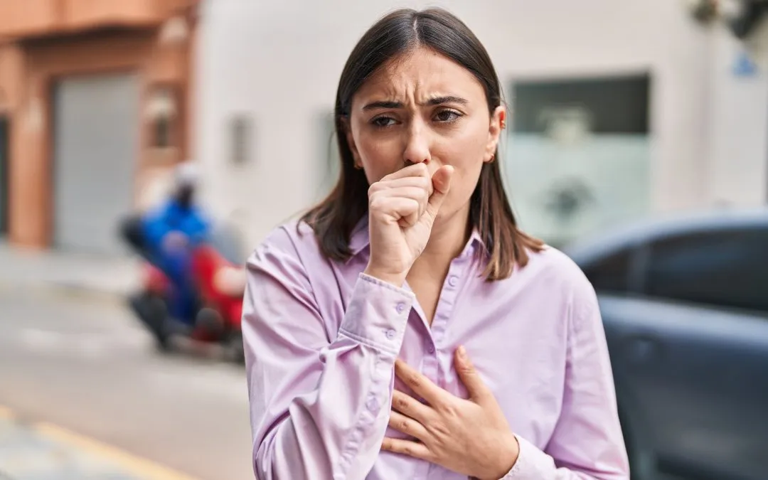 Young woman coughing on the street